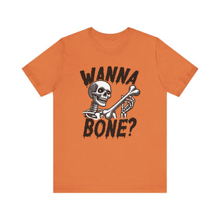 Orange T-shirt with the phrase Wanna Bone around a grinning skeleton holding a large bone
